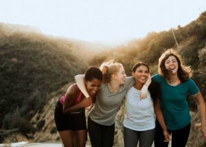 Group of diverse women smiling and supporting each other outdoors – symbolising community and support for those with endometriosis