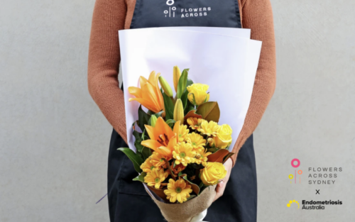 Florist holding yellow bouquet featuring lilies and gerberas, showcasing Flowers Across Sydney's partnership with Endometriosis Australia